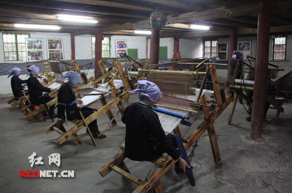 牙屯堡镇枫香村，粟田梅用娘家的木楼办起了侗锦传习所，手把手教姐妹们织侗锦。