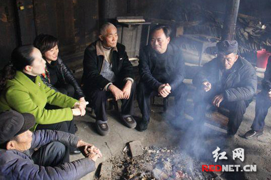 通道县坪坦乡横岭村，老旧的鼓楼里印宇鹰（右二）与乡亲们围着火塘聊旅游、拉家常。
