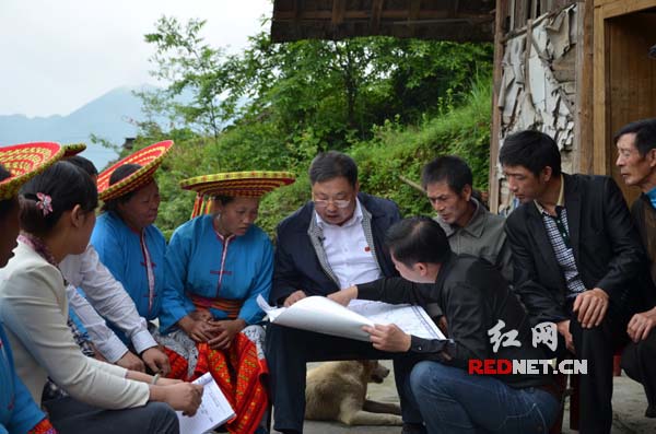 5月23日，九溪江乡宝山村。蒙汉（中）与村民和邻县隆回的村支书门开起了修路方案的“算账会”。