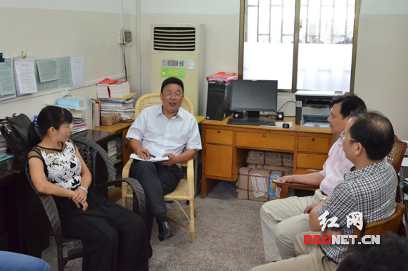 9月4日，郴州资兴市委书记陈荣伟（中）向资兴市立中学的教师询问高中免费后的学生情况。资兴自去年起实施高中免费教育。陈荣伟说，这是为所有资兴孩子的未来投资。