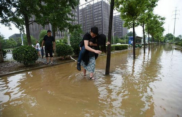 [视频]武汉：姑娘背小伙 涉水过马路