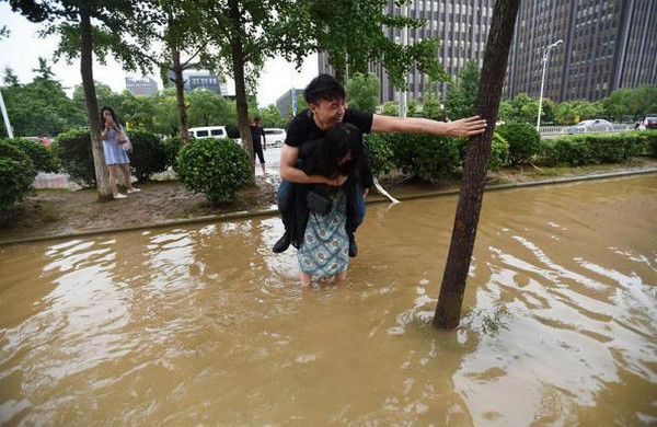 [视频]武汉：姑娘背小伙 涉水过马路